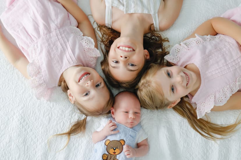 Overhead portrait of three sisters circled around their newborn baby brother, Metro Detroit newborn session