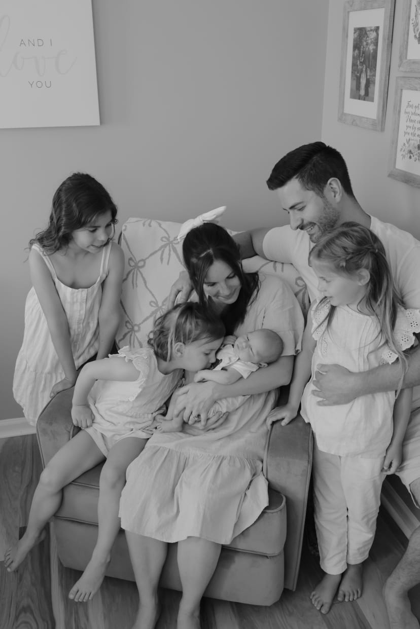 Black-and-white family portrait welcoming a newborn at home, Metro Detroit newborn session