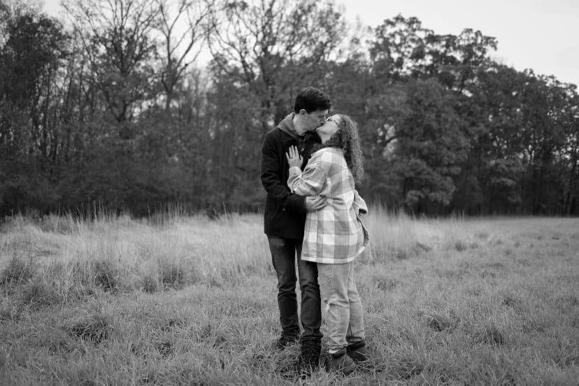 Black-and-white photo of a couple embracing in a field, southeast Michigan engagement