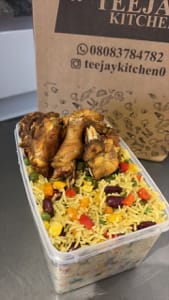 A bowl of fried rice, salad, plantain and turkey