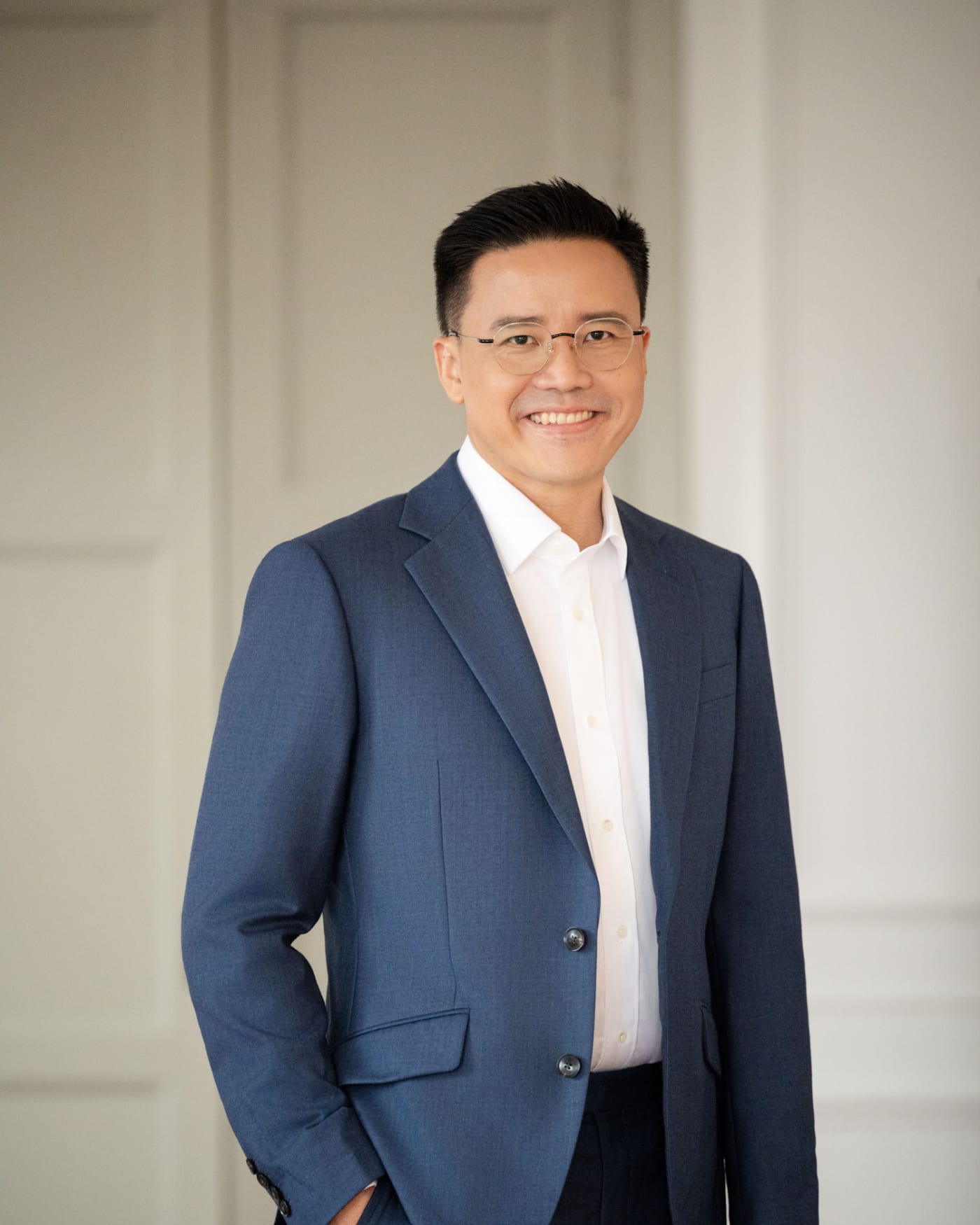 Wallace D. Wong, standing, in a navy jacket and open-collar shirt