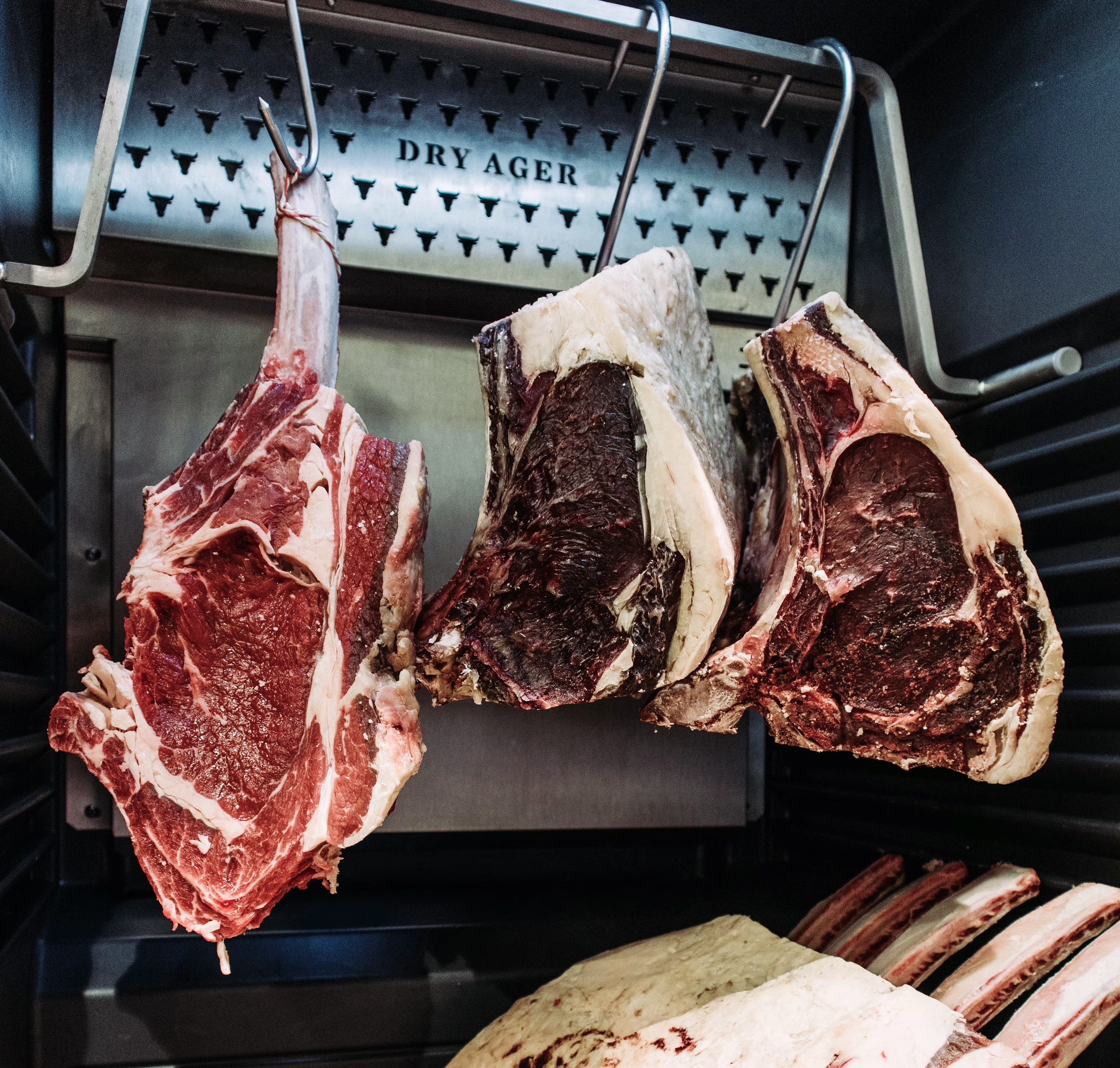 Dry-aged beef hanging in a dark aging room