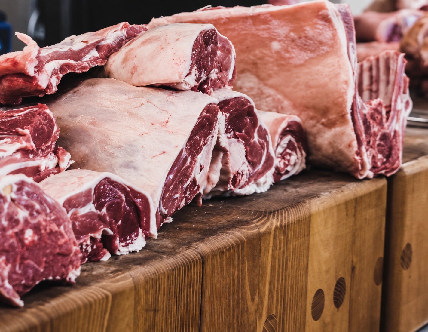 Clean butchery work on a light butcher block surface, professional knife handling