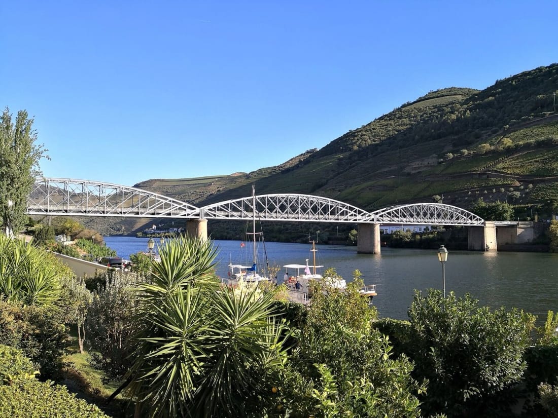 The Gustave Eiffel bridge over the Douro at Pinhão, with boats moored below terraced vineyards
