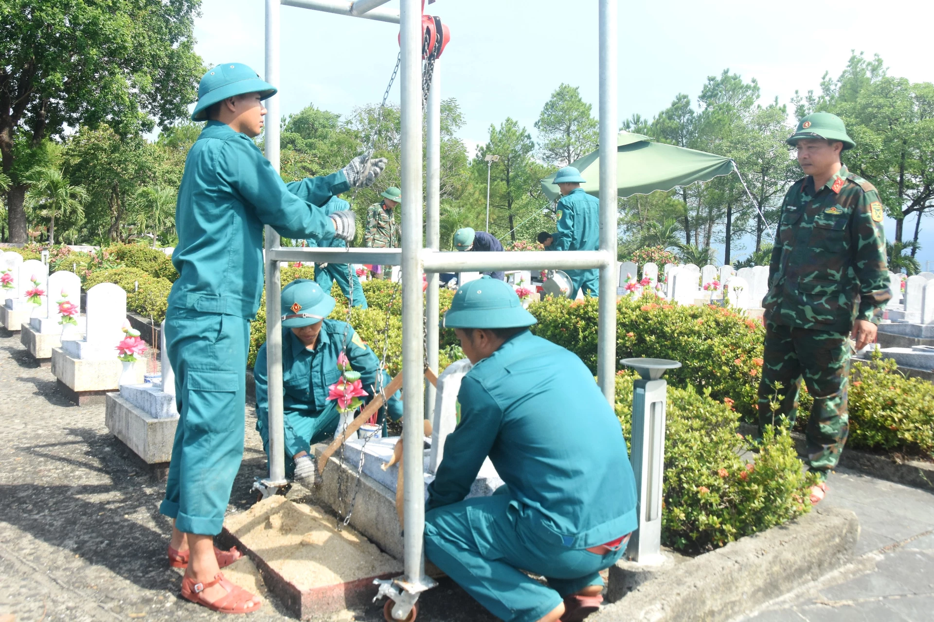 Các lực lượng vũ trang phối hợp công tác cất bốc, xác định danh tính hài cốt liệt sĩ tại Nghĩa trang liệt sĩ quốc gia Đường 9 - Ảnh: Đ.V