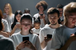 group of young people  looking at their phones in white shirts