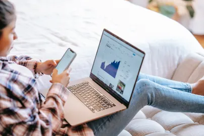 man using phone and laptop for web browsing