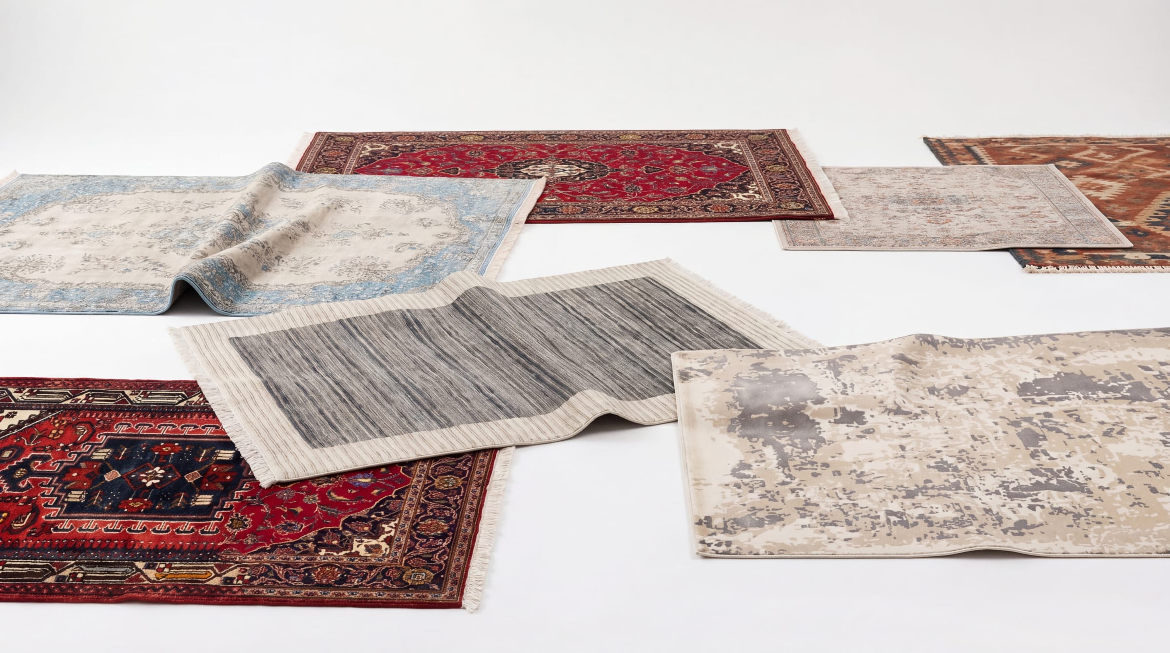 A curated selection of handmade Persian, modern, and tribal rugs in studio lighting
