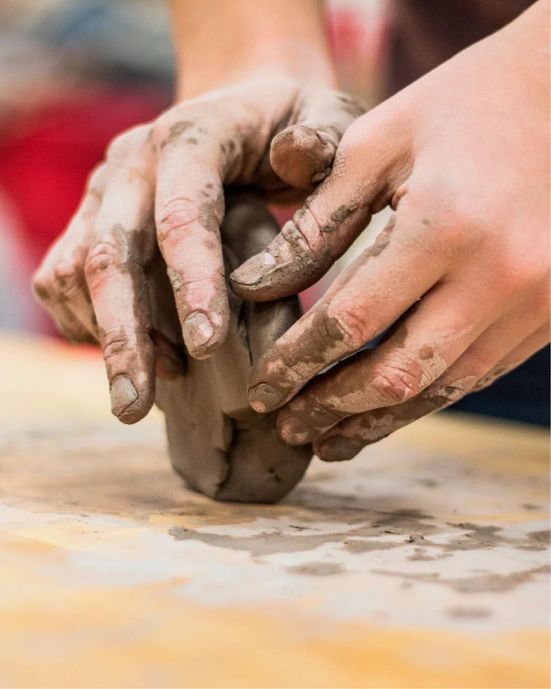 Manos trabajando un bloque de arcilla