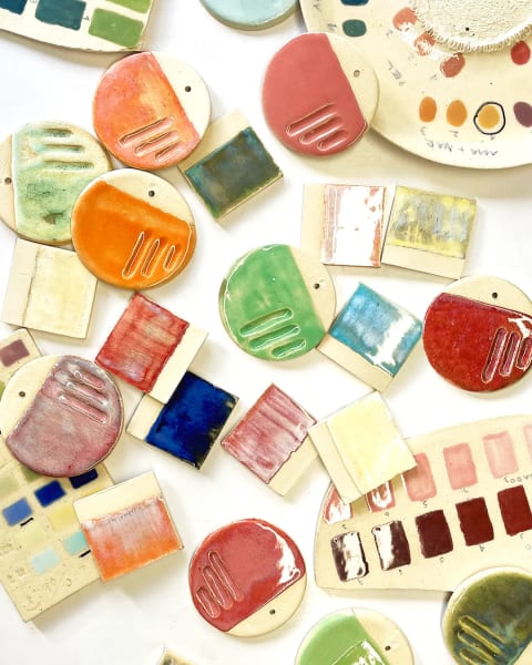 Vista cenital de muestras de cerámica de colores sobre una cubierta blanca