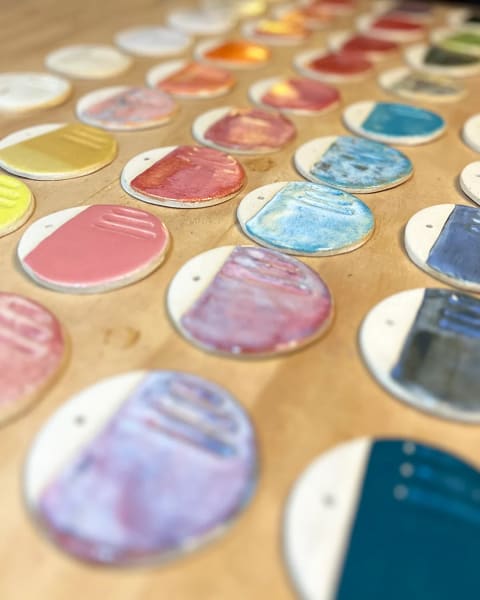 Vista en perspectiva de muestras de cerámica de colores sobre una cubierta de madera