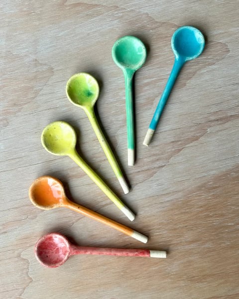 Cucharitas de colores sobre mesa de madera