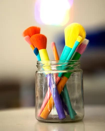 Frasco de vidrio con pinceles de colores