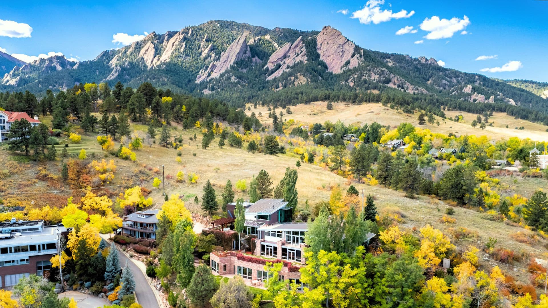 beautiful mountain home in a valley below a mountain on a sunny day