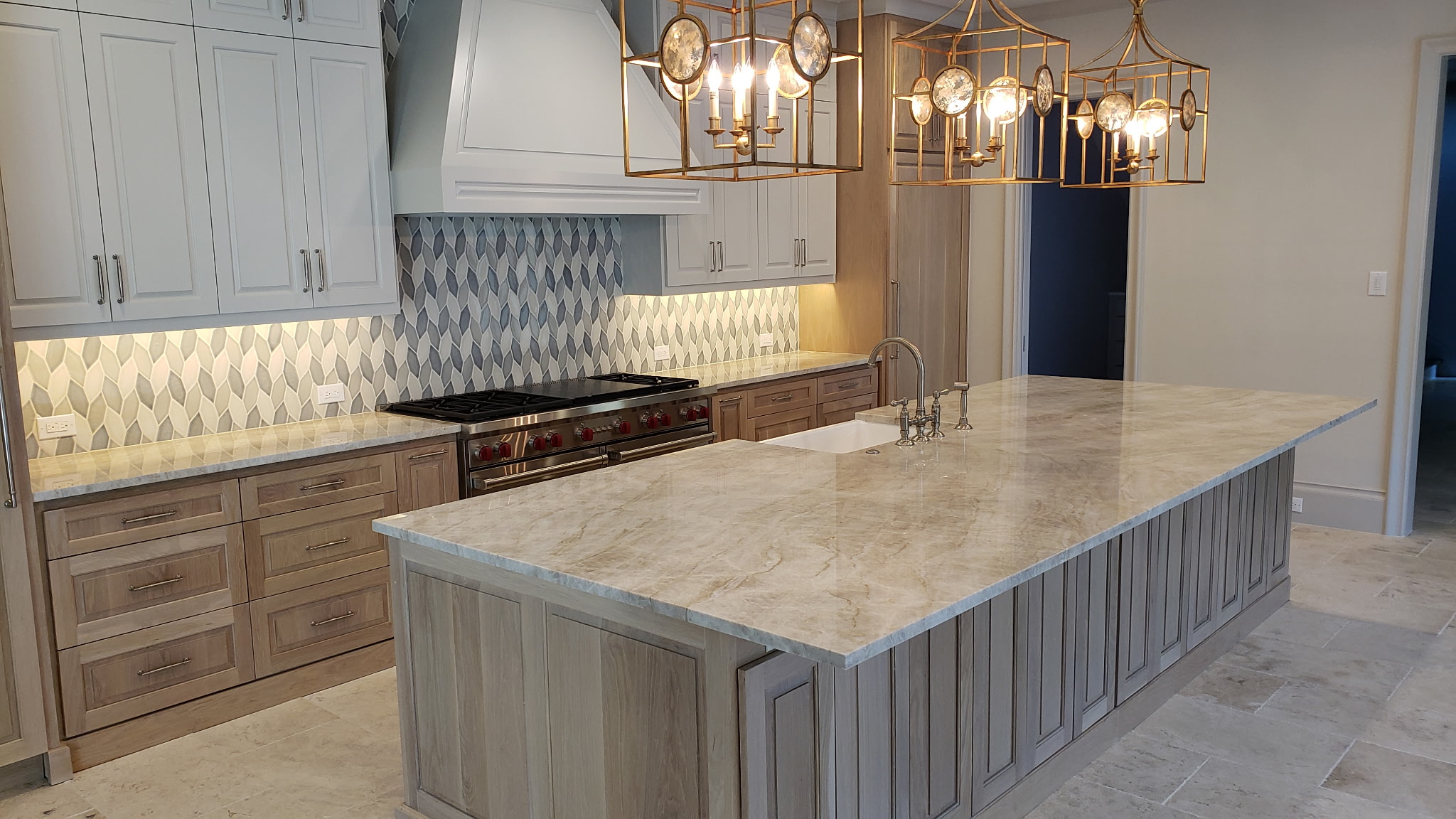 Luxurious quartzite kitchen countertop with striking veining, complemented by modern cabinetry and elegant pendant lighting, showcasing a blend of durability and aesthetic appeal.