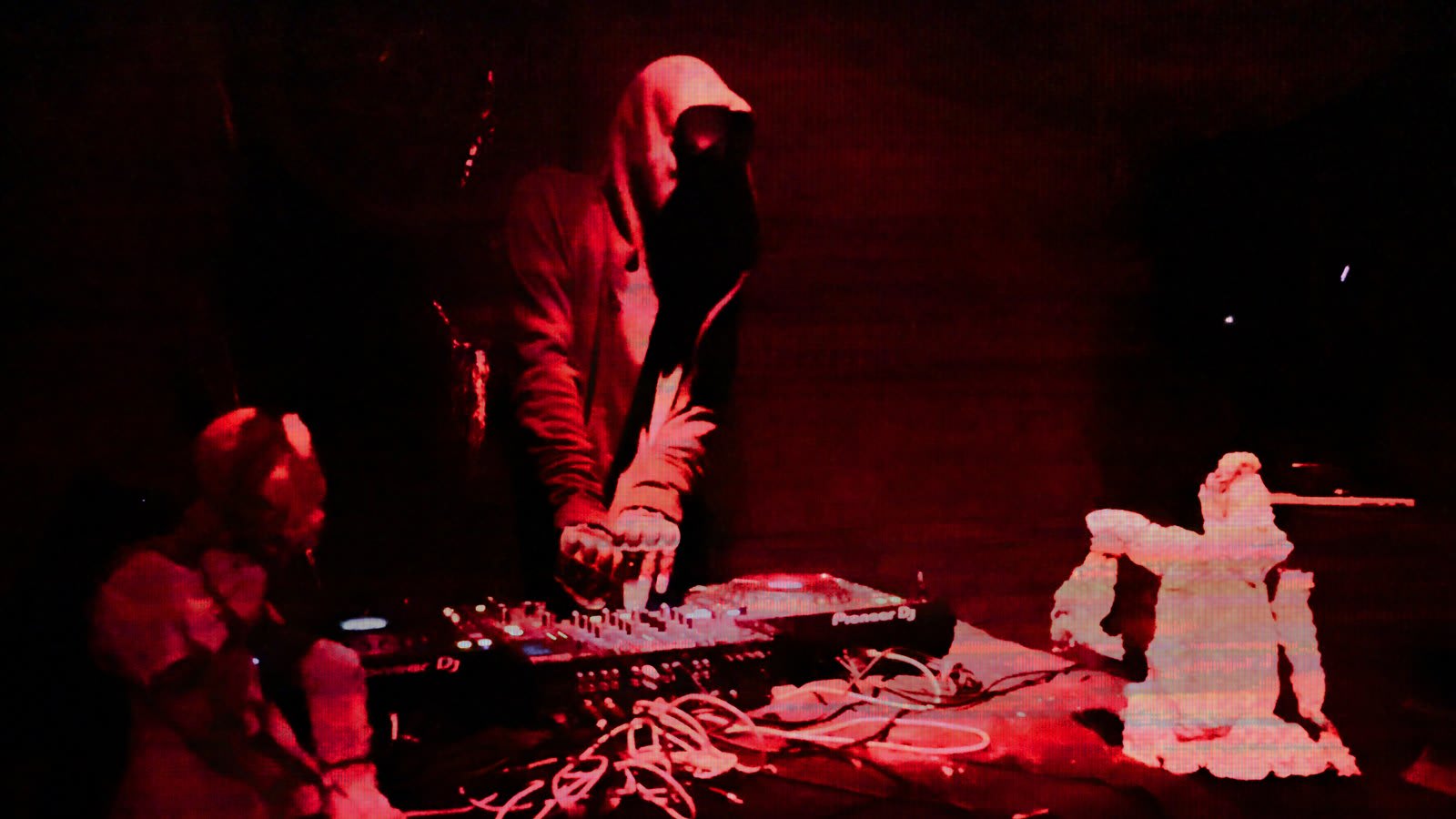 MAN1K, hooded, at the decks under red light