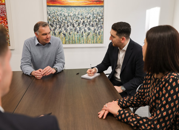 A group of professionals engage in discussion around a conference table.