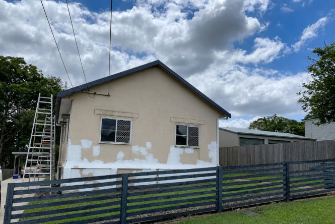 Residential exterior with peeling and patchy render on rendered brick home prior to repainting. Exterior painting preparation by Blue Collar Painting, Gold Coast.