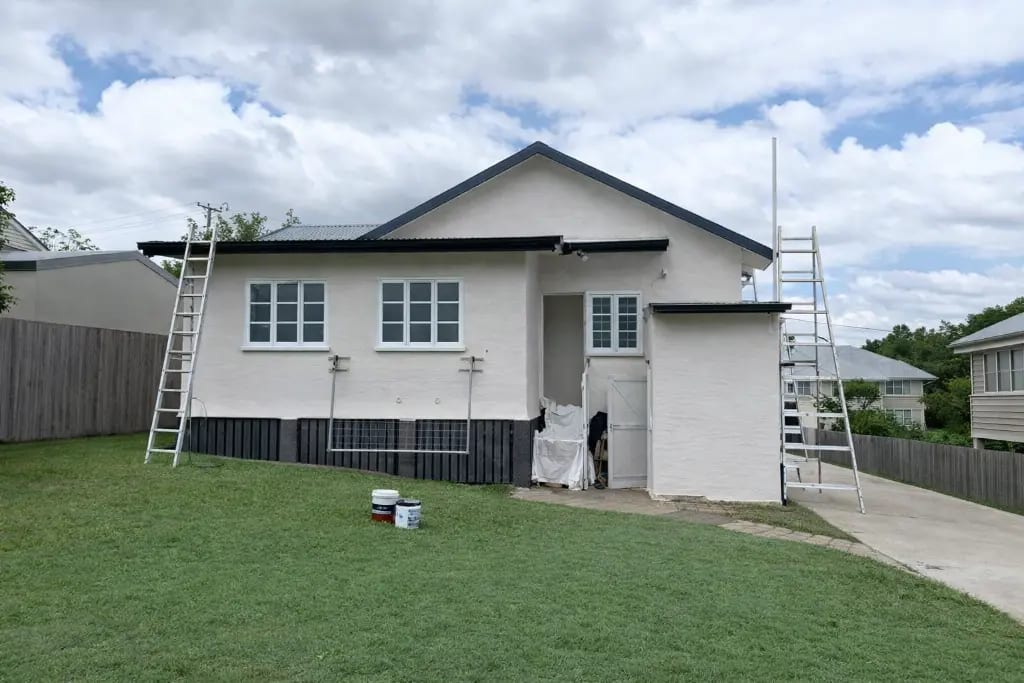 Strata building painting preparation with ladders before exterior repaint on the Gold Coast