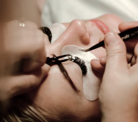 A student applying an eye mask to a customer