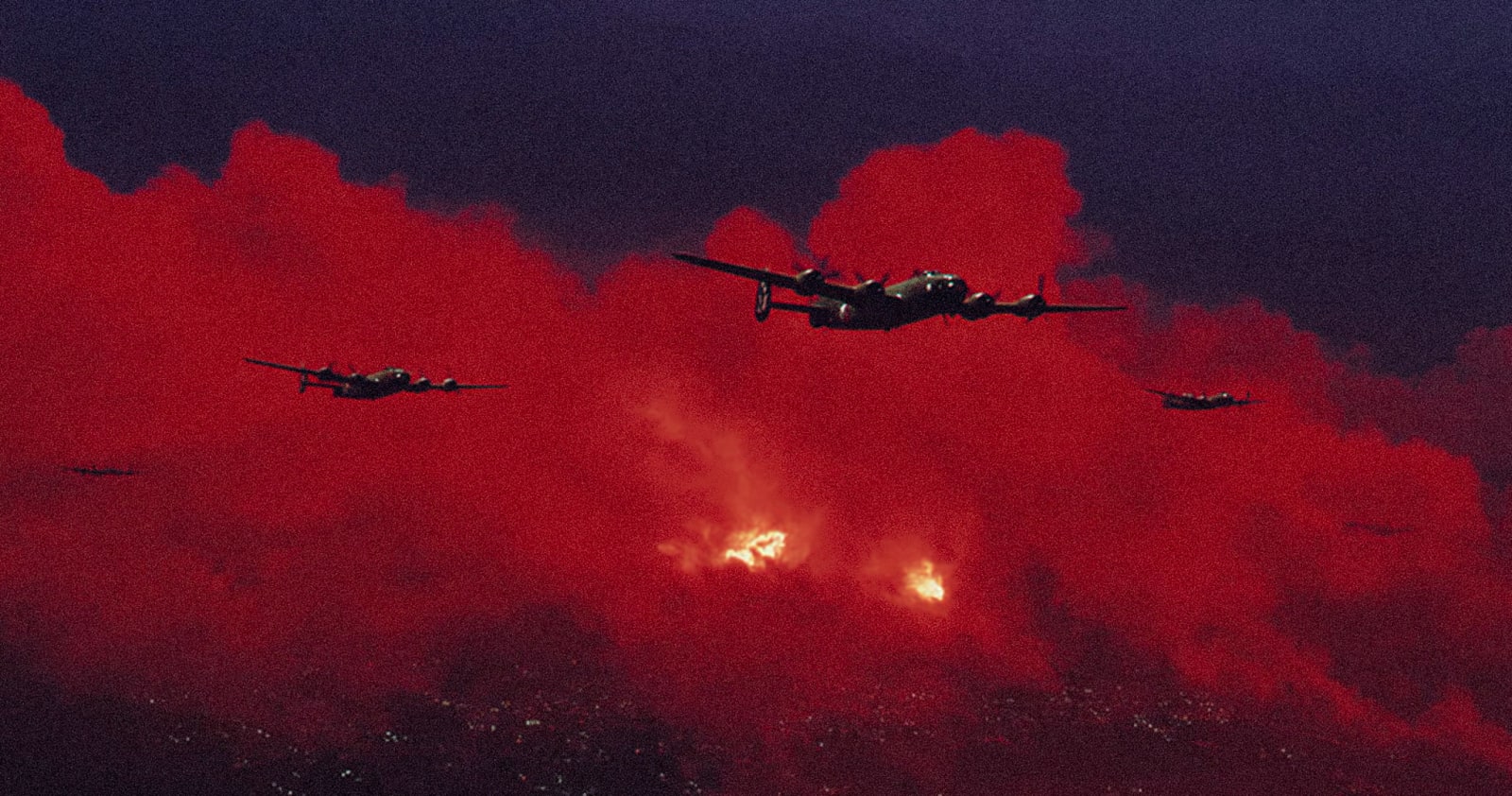 A group of airplanes flying in the night sky with red smoke trails.