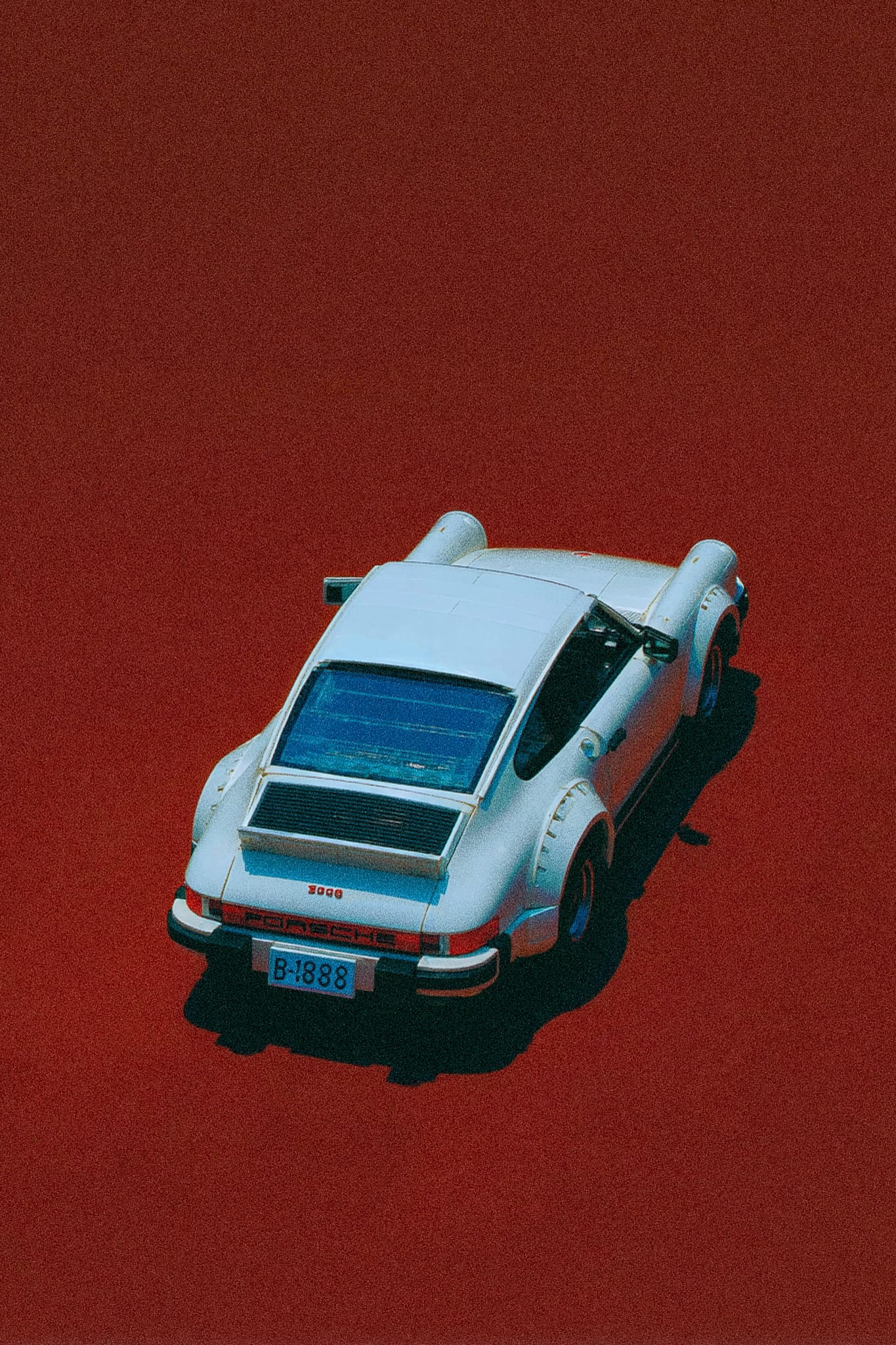 A white sports car with a red background.