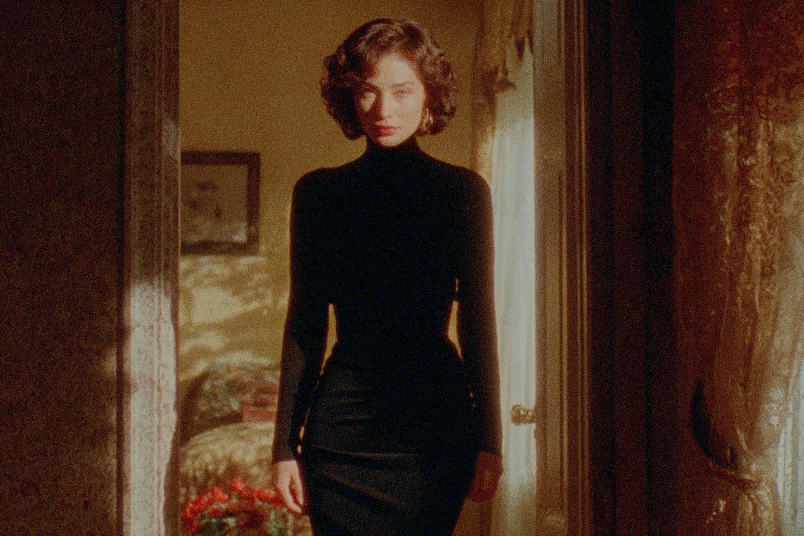 A person in a black dress standing in a doorway.
