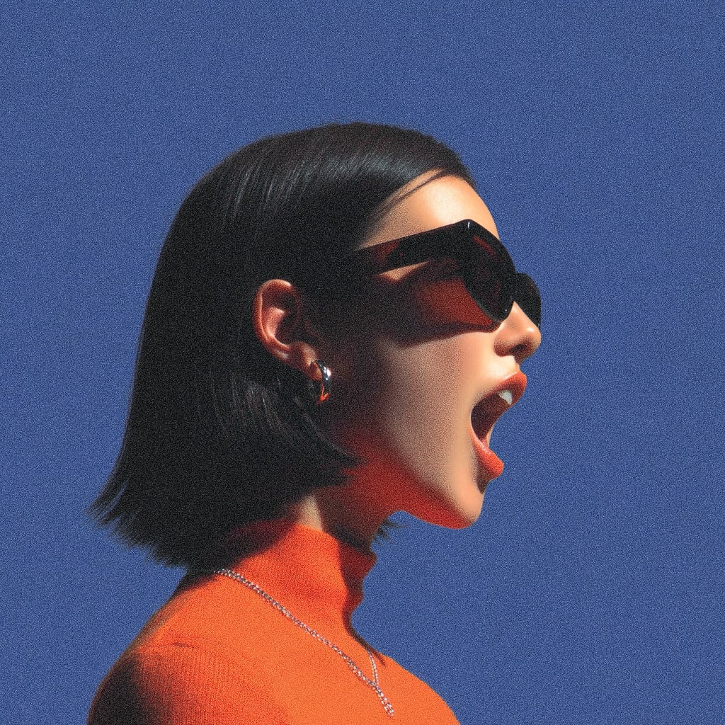 A person with black hair and sunglasses against a blue background.