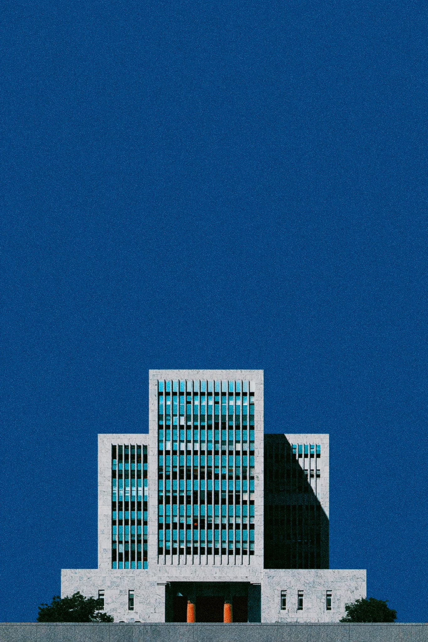 A modern building with blue windows against a deep blue sky.