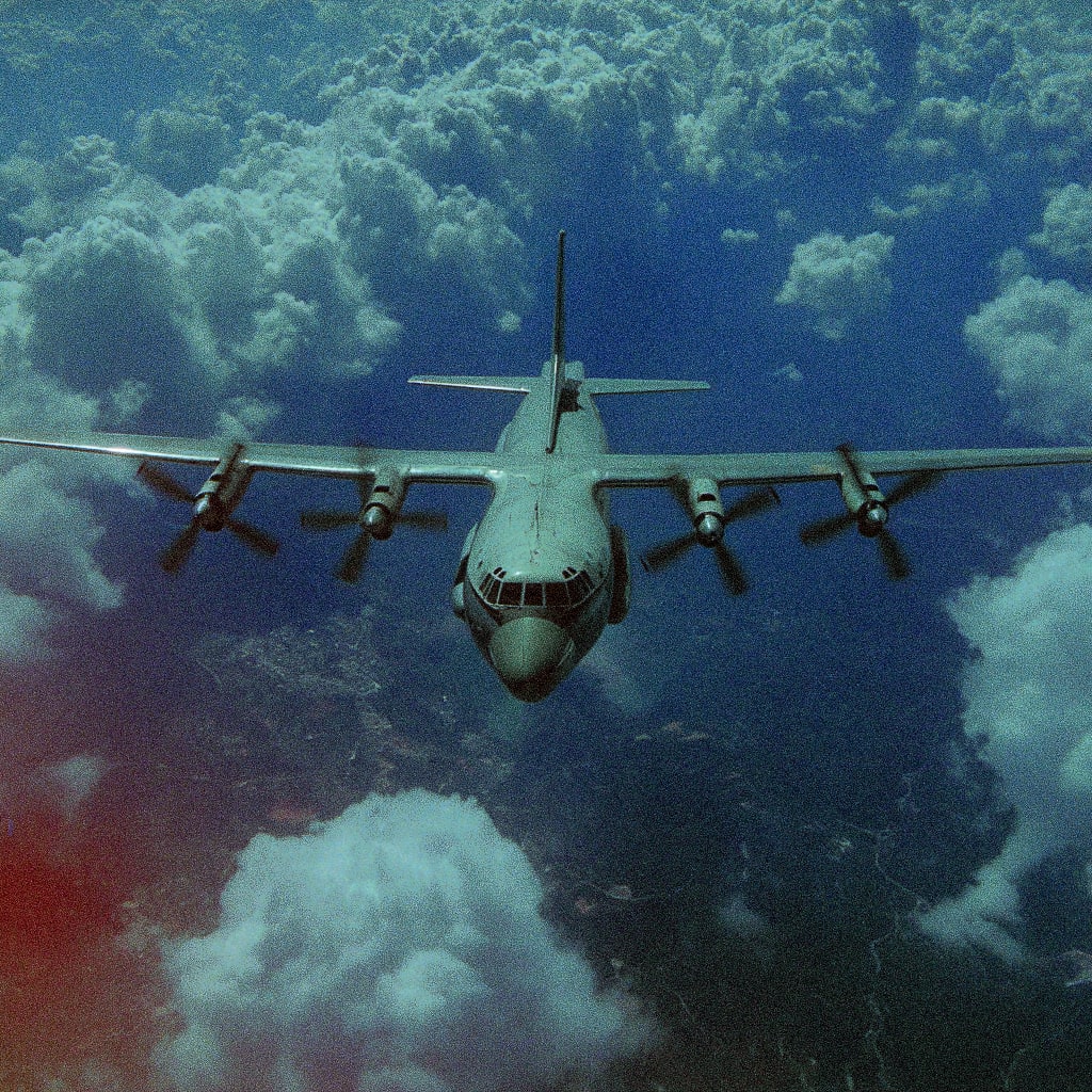 A military transport plane flying over lush greenery.