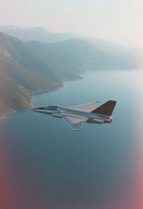 A jet flying over a lake and mountains.