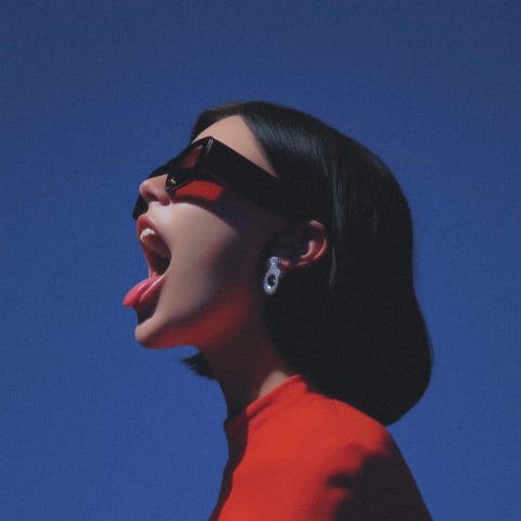A person wearing sunglasses and a red top with a black background.