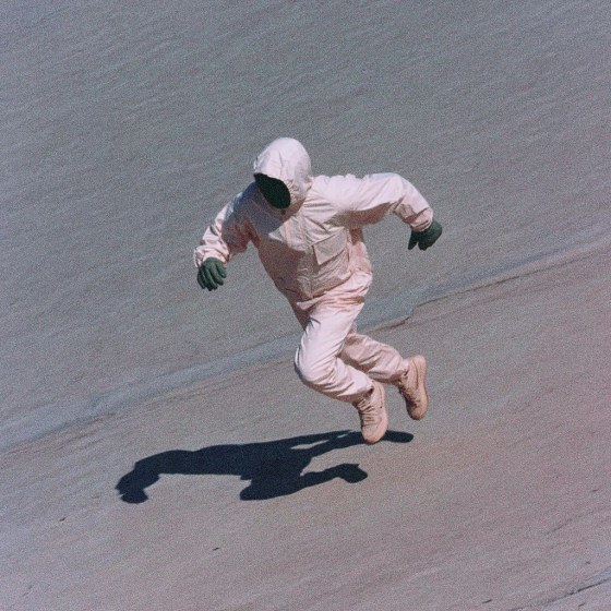 A person in a white suit jumping in the air.