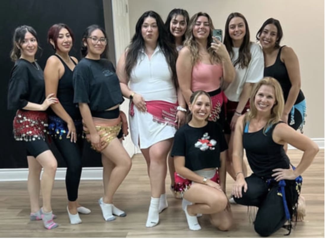 A bellydance party group at Mayada's Dance & Fitness — guests in hip scarves