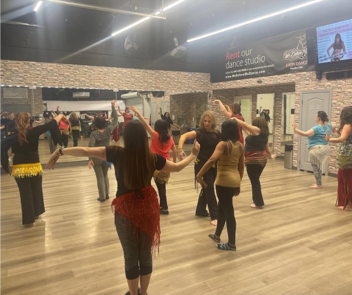 A bellydance class at Mayada's Dance & Fitness — dancers in hipscarves learning together