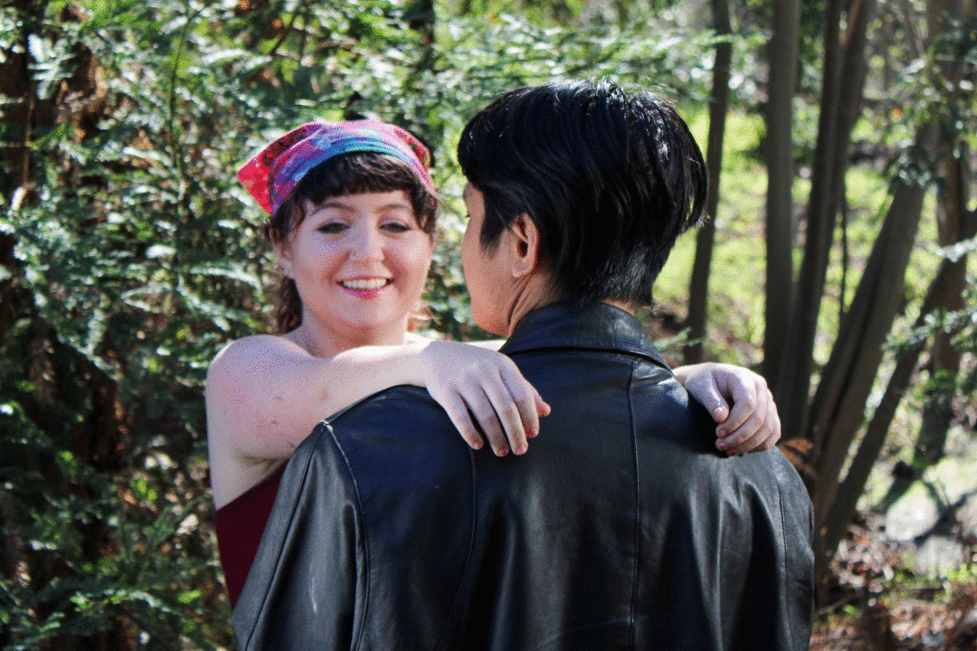 A woman facing a man with her hands on his shoulders