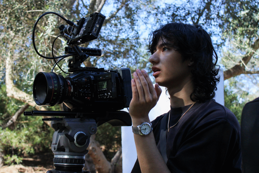 A man with a film camera looking upwards