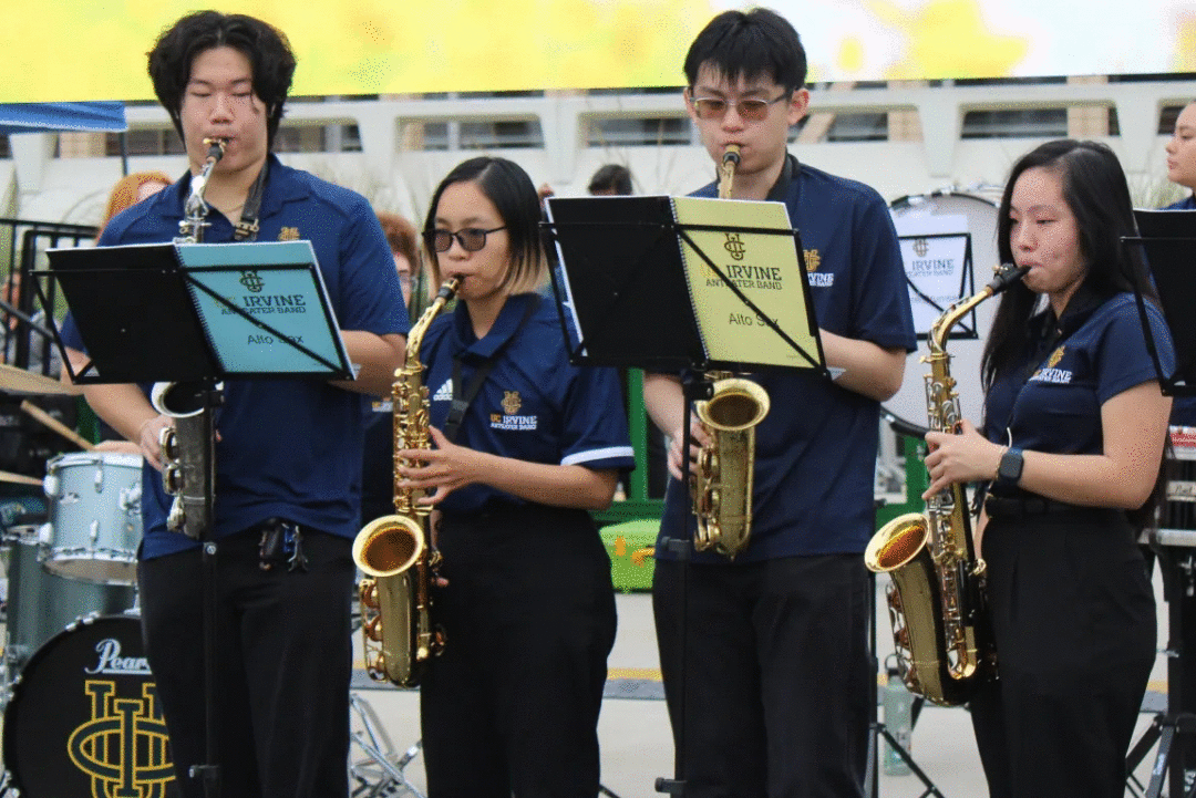 A row of people playing the alto saxophone in a pep band