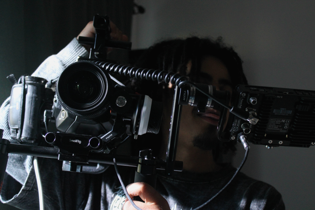 A man looking through a film camera