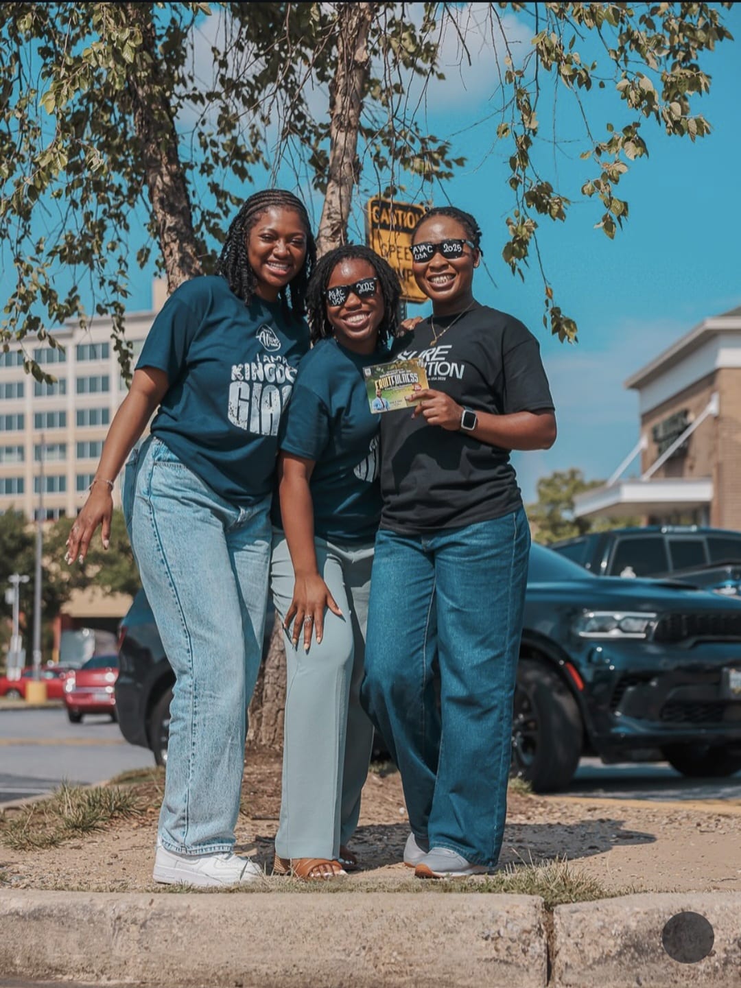Three women in Kingdom Giant tees at community outreach
