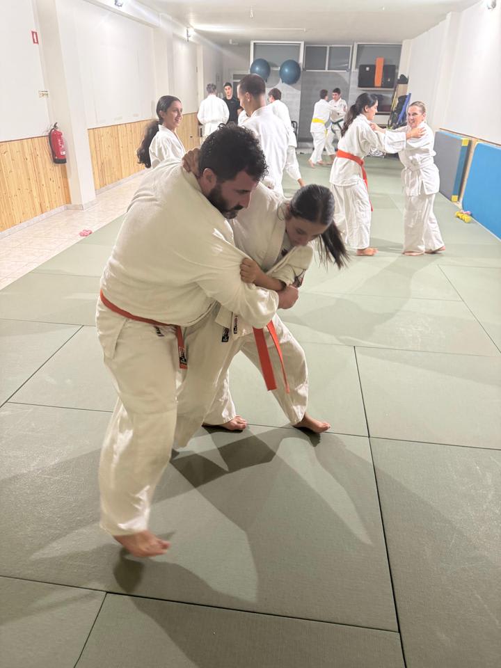 Dois alunos adultos a treinar uma técnica de controlo no tatami