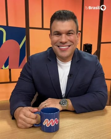 Dr. Rodrigo Schröder sorrindo em um estúdio de televisão