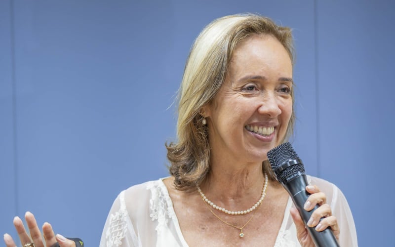 Jaq Priston sorri enquanto fala ao microfone.