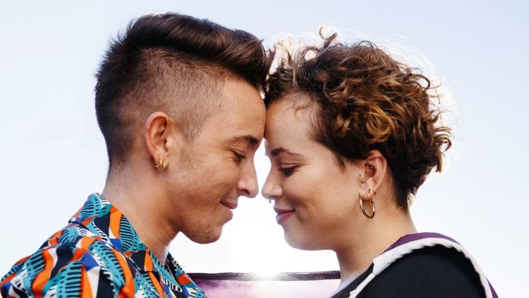 Image of trans couple looking at each other with love