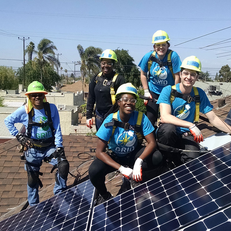 A work crew installs solar panels.