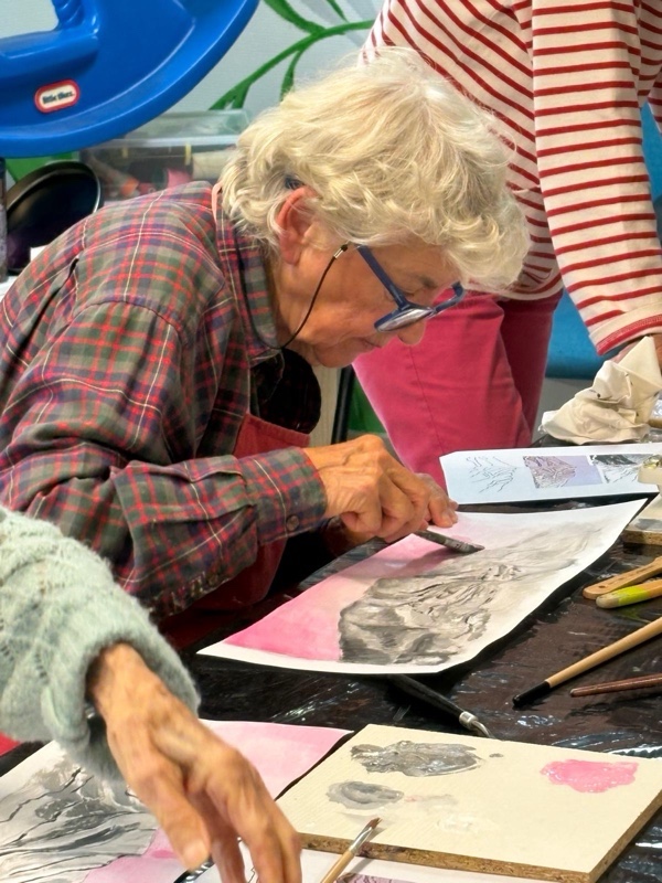 Bénévole animant l'atelier peinture avec un adhérent malvoyant