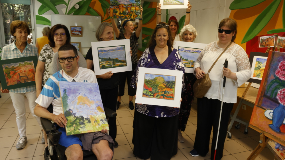 Les bénéficiaires présentent fièrement leurs œuvres lors de l'exposition