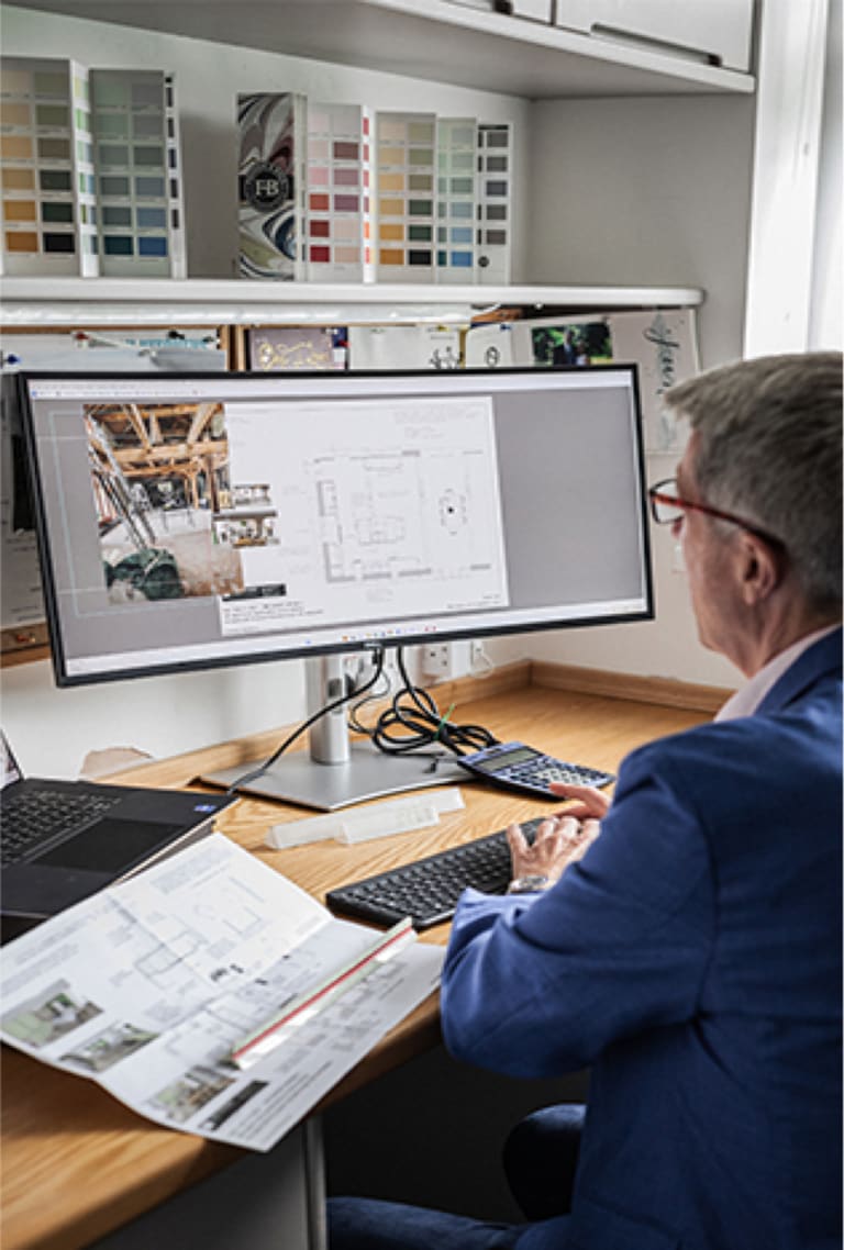 Our Kitchen Designer woking at his computer on digital kitchen designs