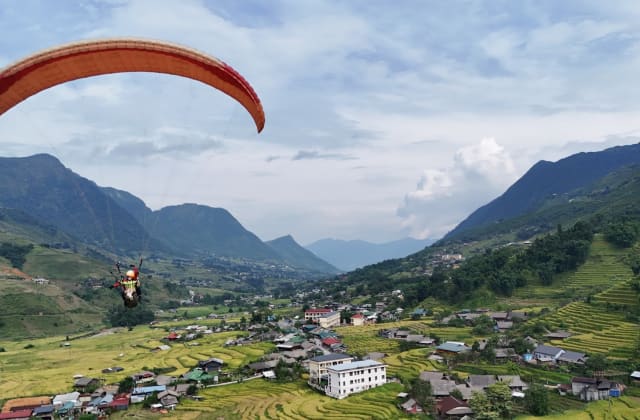 A wing just launched from Hang Da village, with the villages and terraces of Muong Hoa Valley below