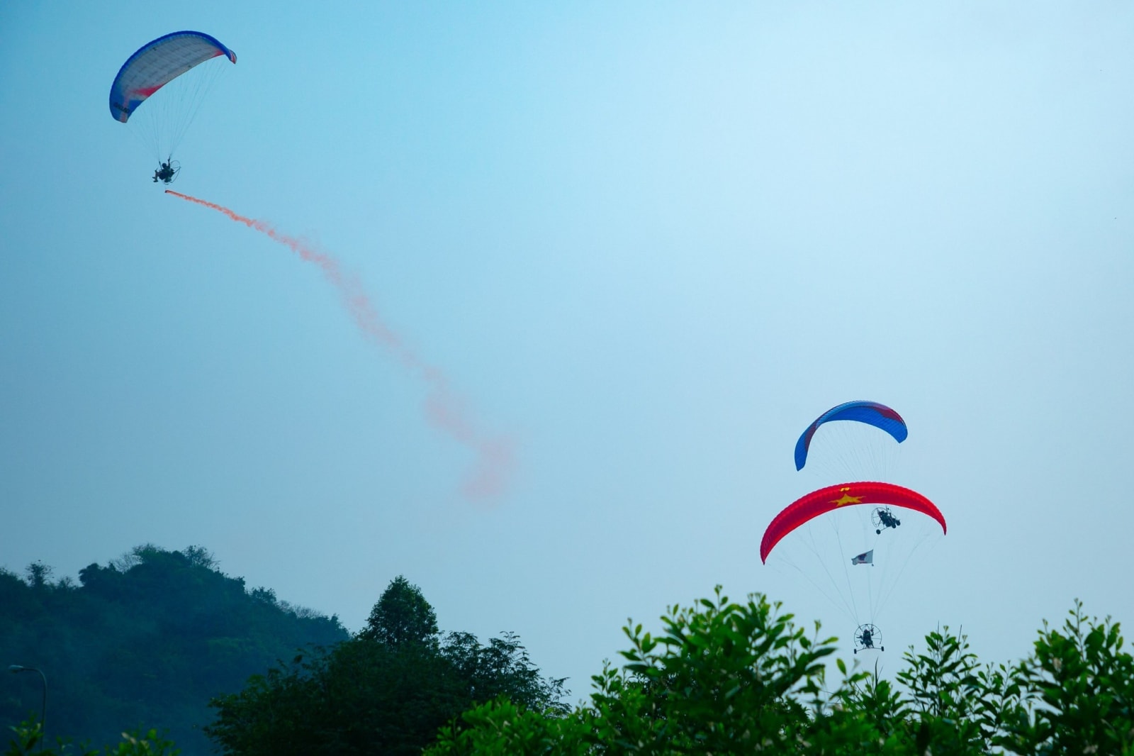 Smoke effects beneath the paragliders added to the impressive visual display.